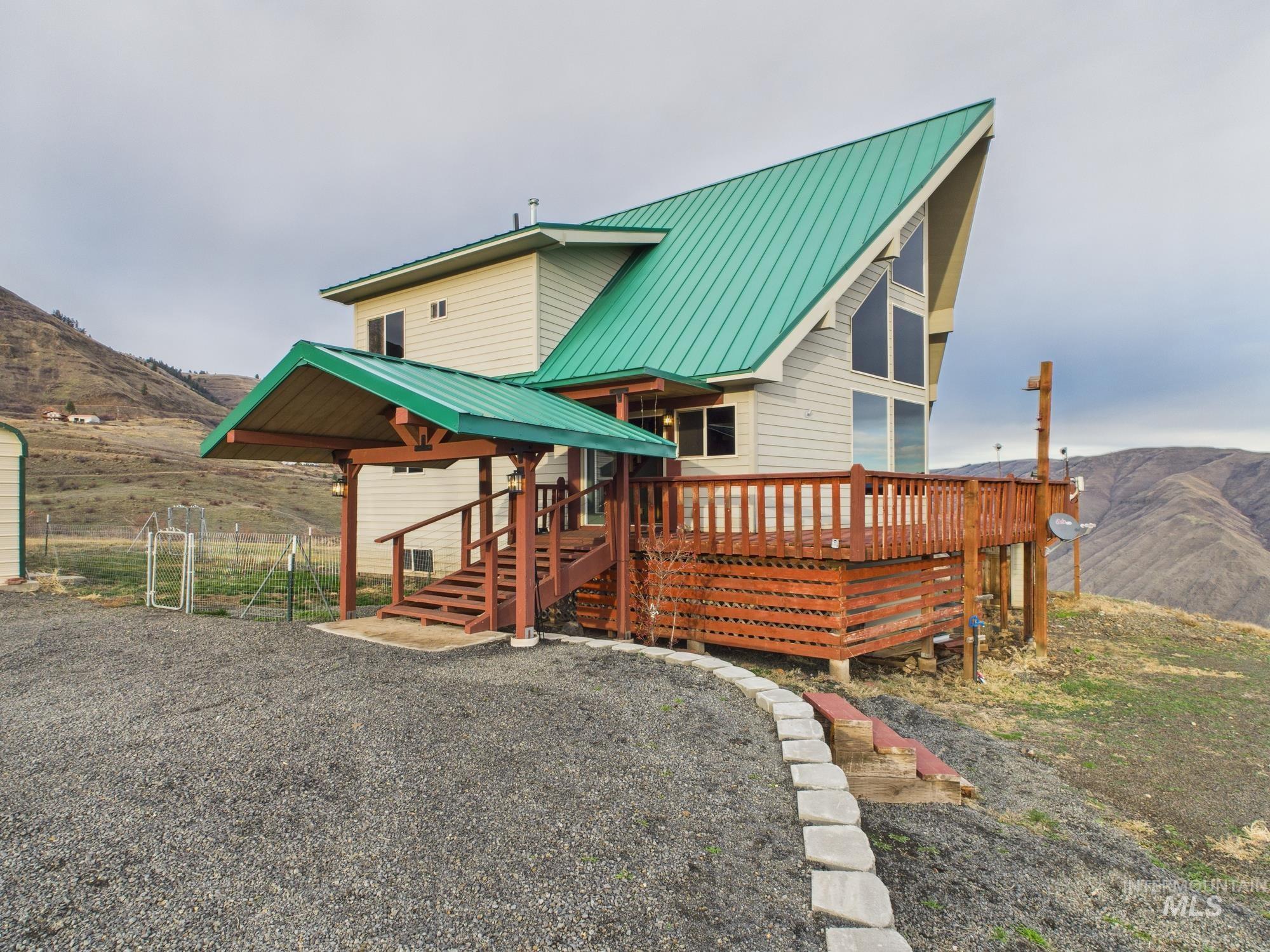 side of property featuring a metal roof and a deck with mountain view