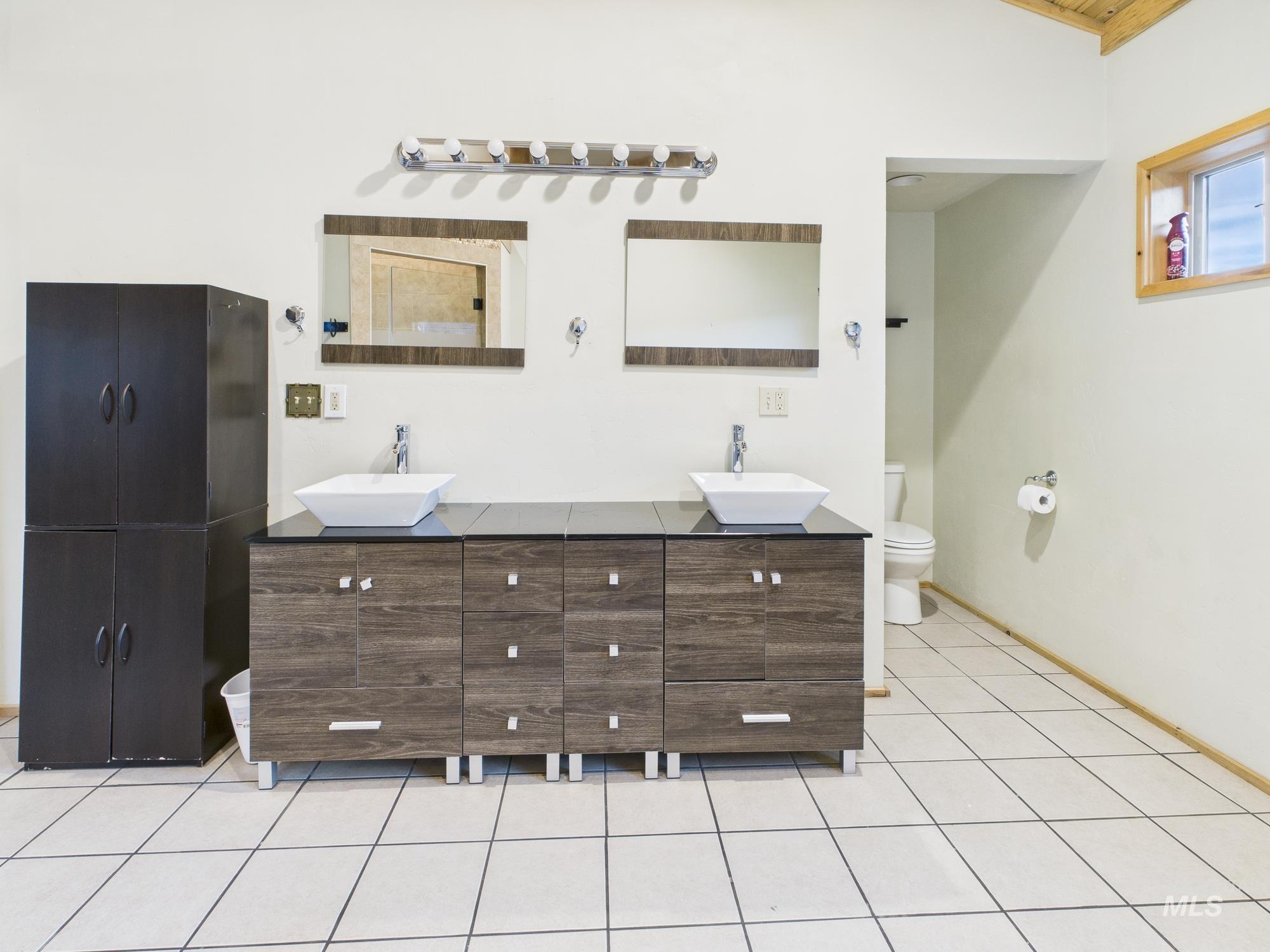 Bathroom featuring double vanity and light tile patterned floors