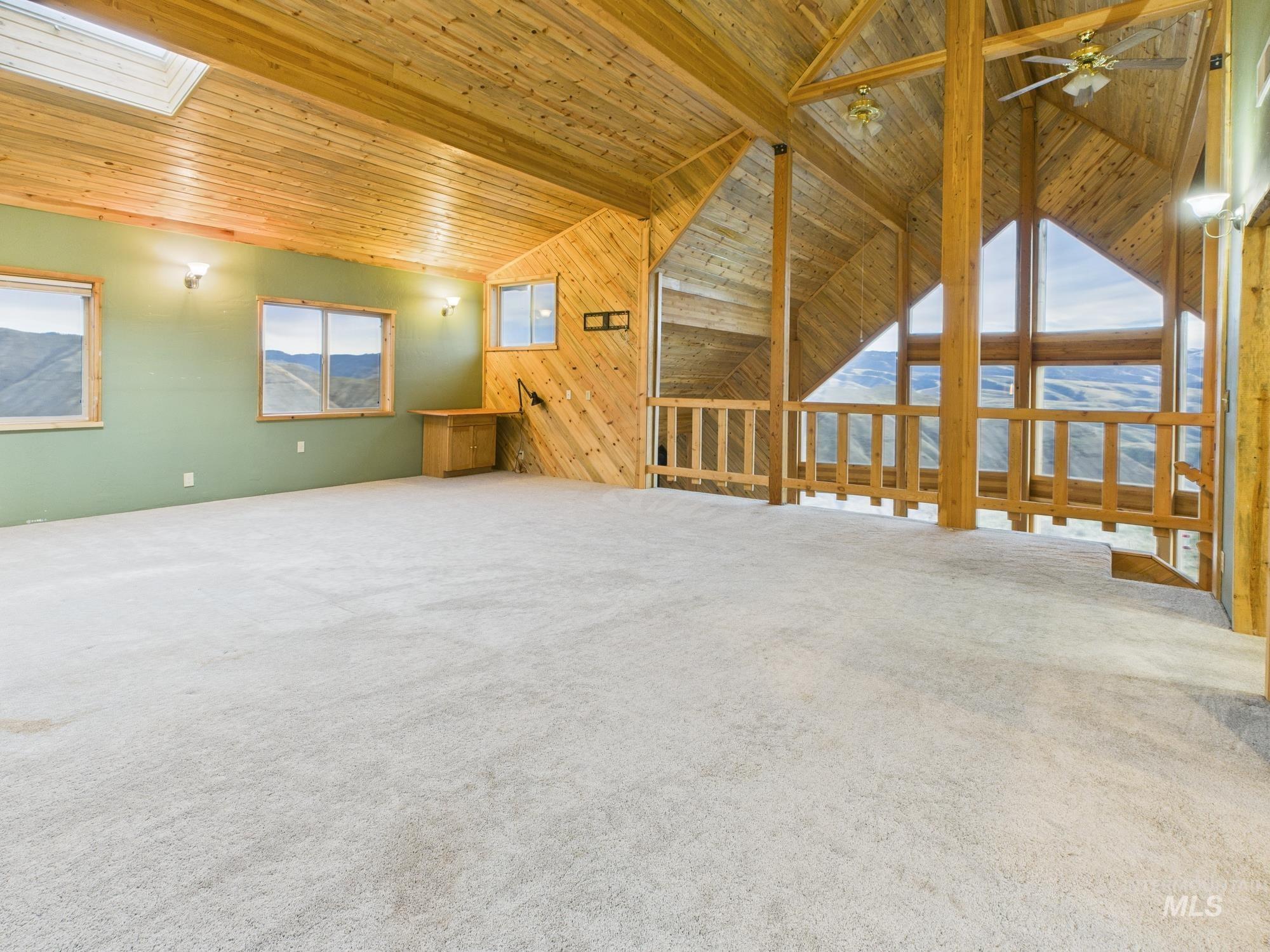 Master bedroom featuring wood walls, healthy amount of natural light, lofted ceiling, wooden ceiling, and carpet floors