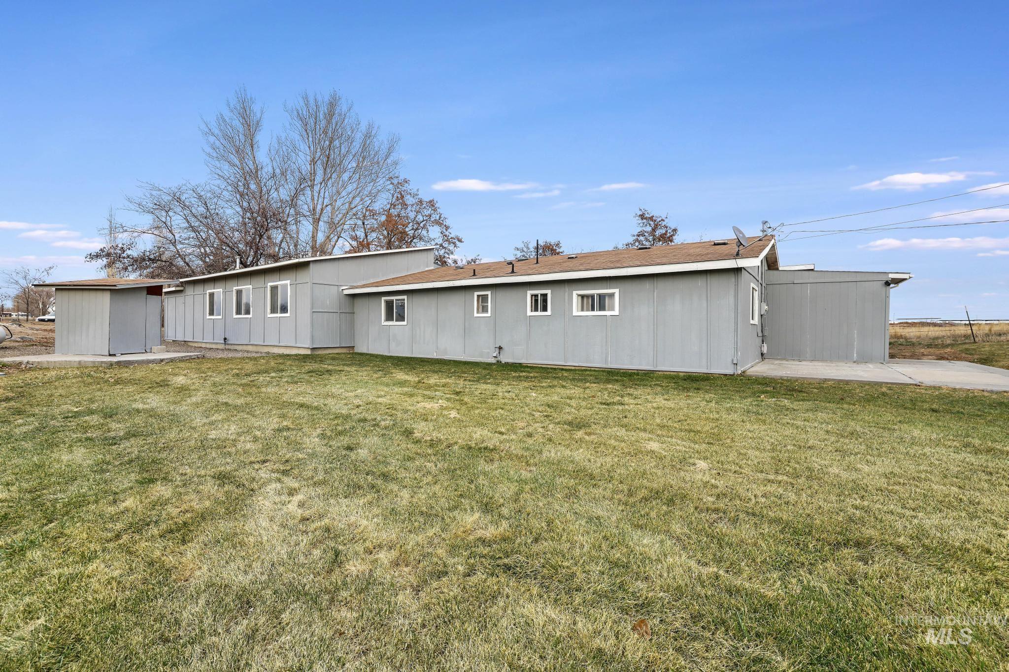 Rear view of property featuring a yard and a patio