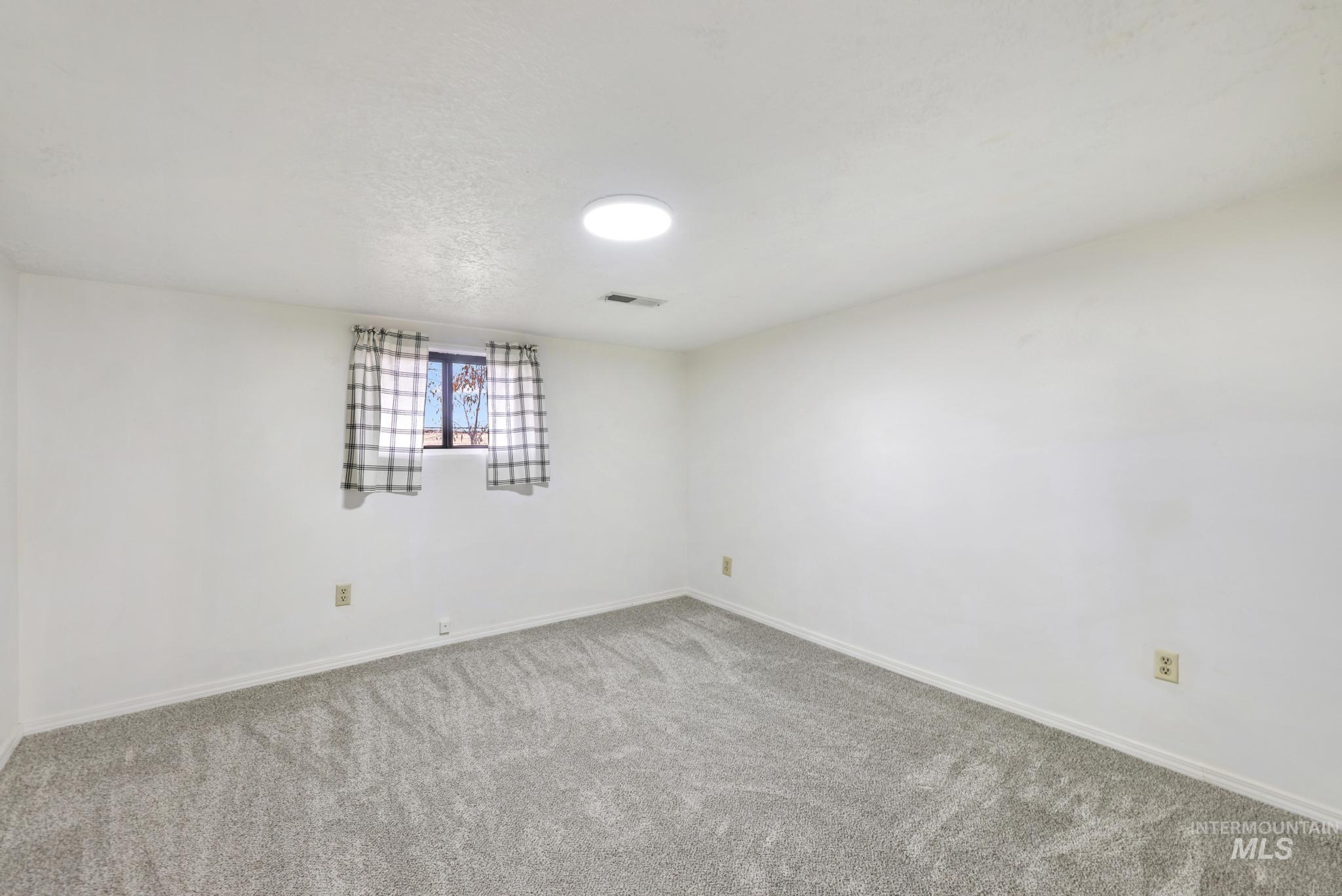 Carpeted empty room with baseboards and a textured ceiling