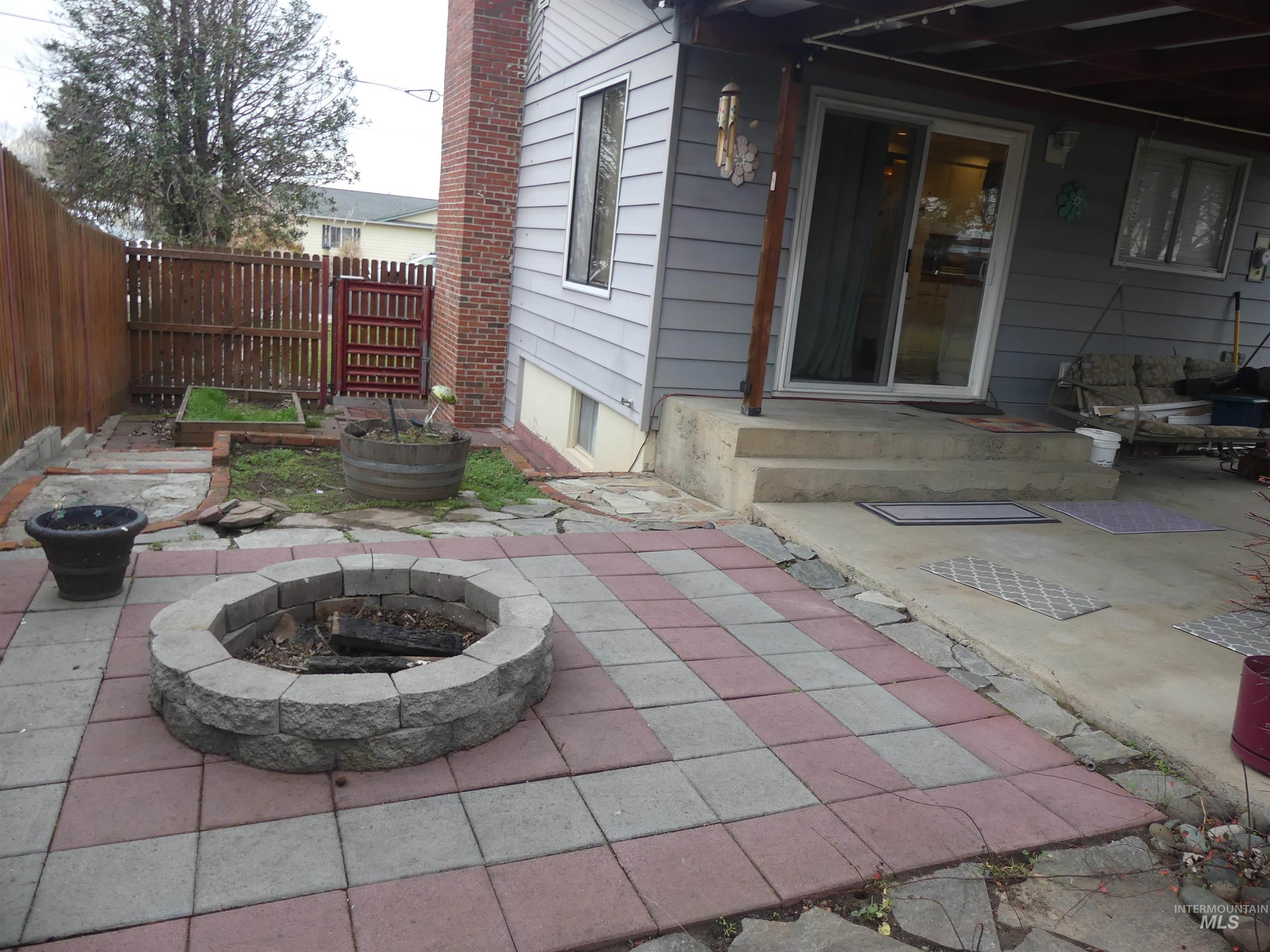 Fenced backyard with a patio area and a fire pit