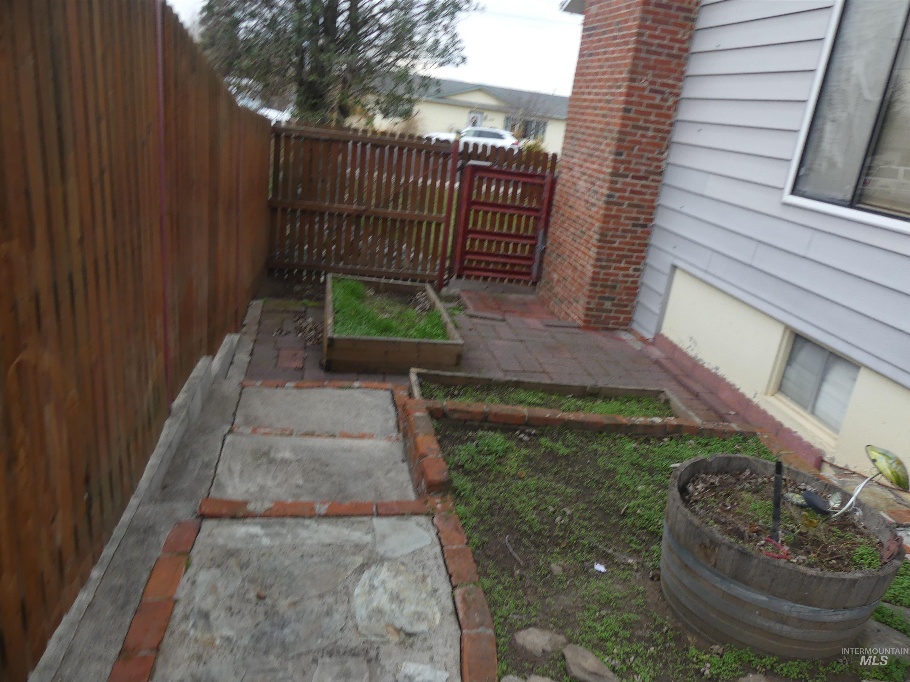 Fenced backyard with a patio area and a garden
