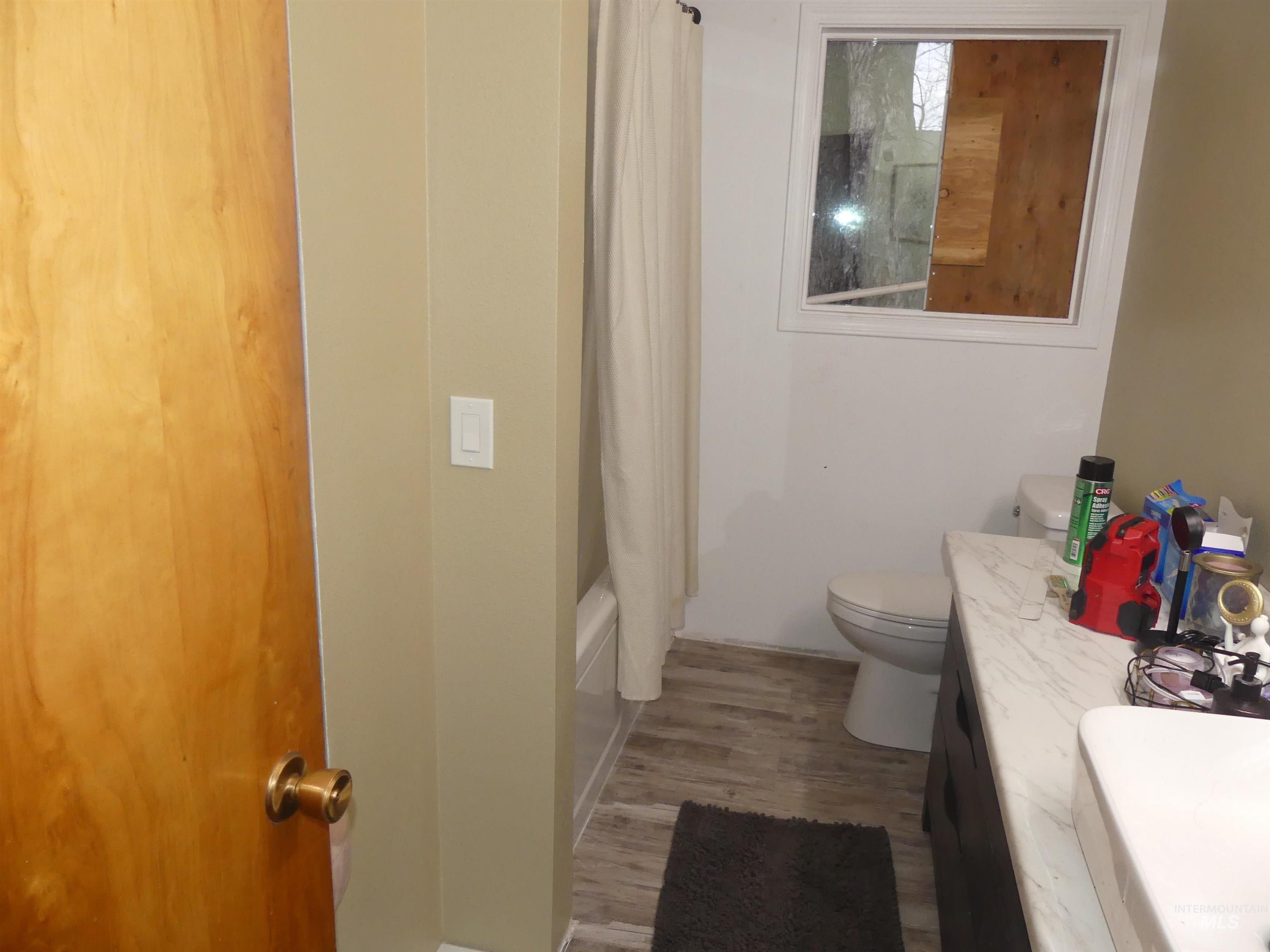 Bathroom featuring vanity, light wood-type flooring, and shower / tub combo with curtain