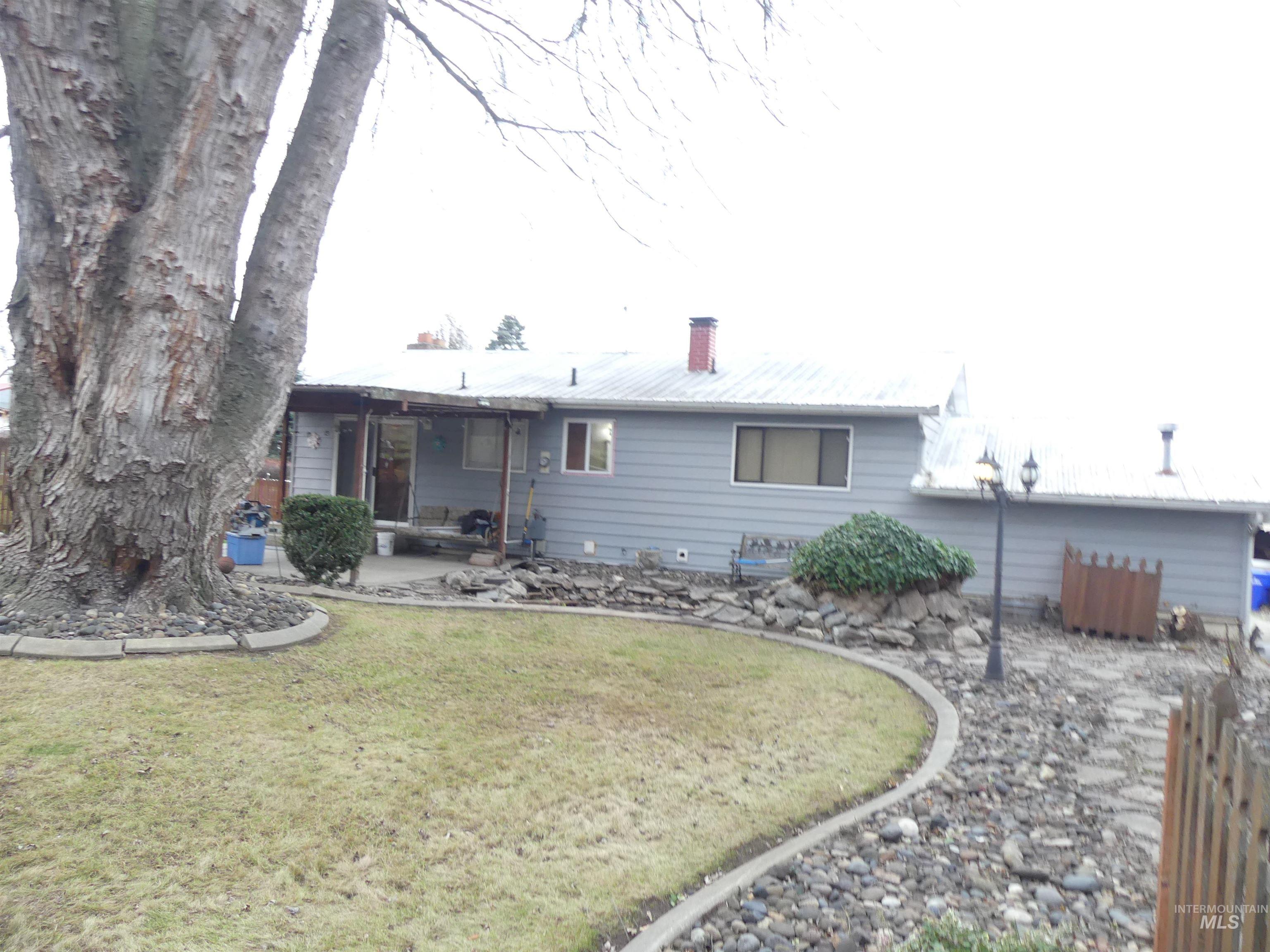 Rear view of house with a chimney and a patio area