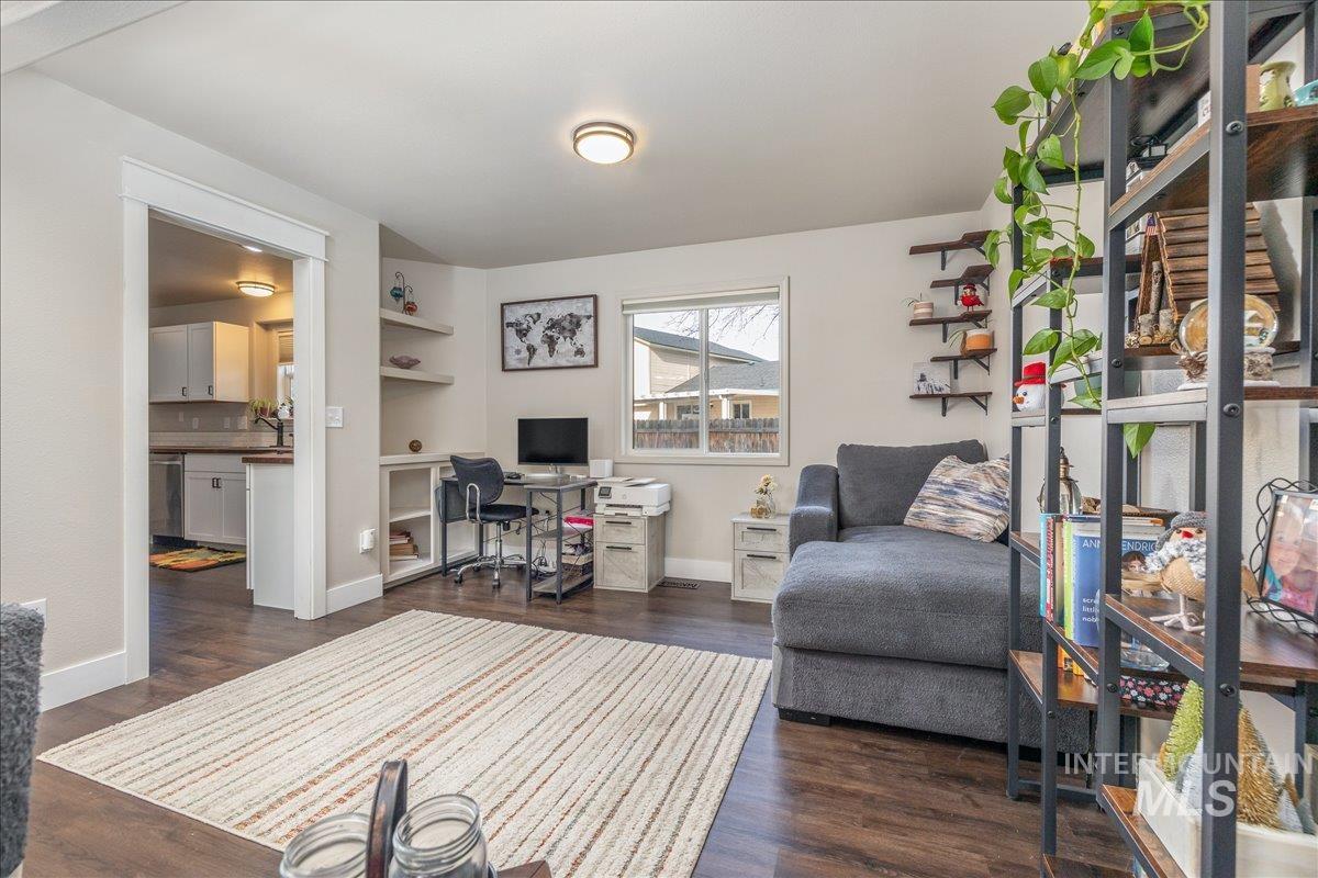 Home office with dark wood finished floors and built in features