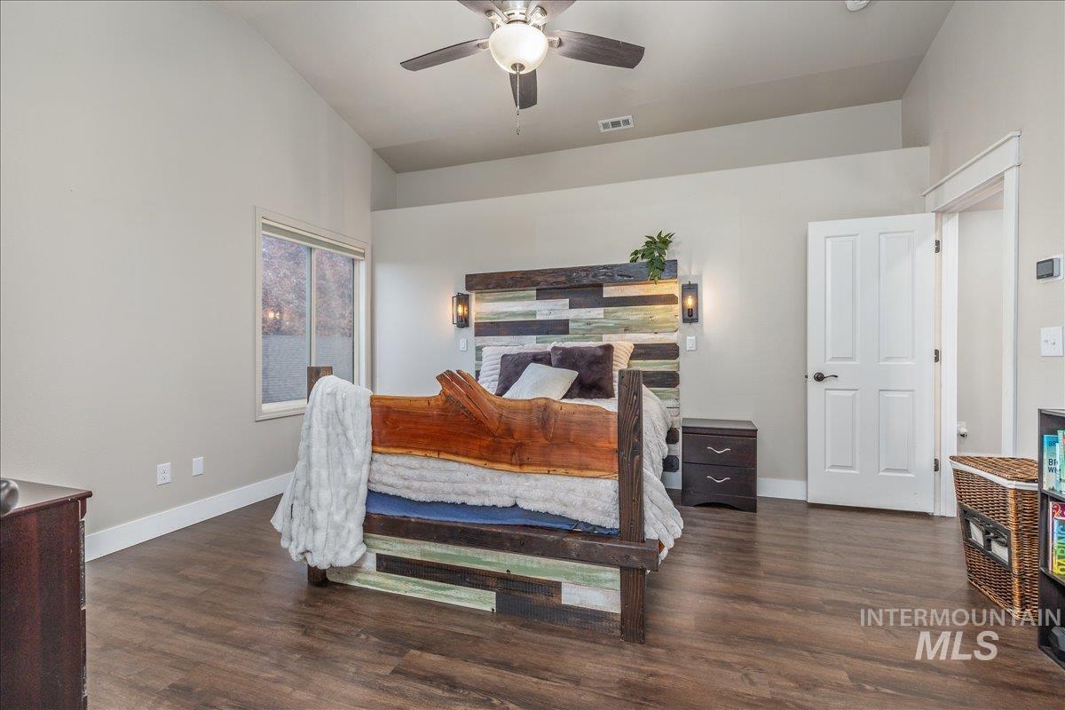 Bedroom with a ceiling fan, dark wood finished floors, and lofted ceiling