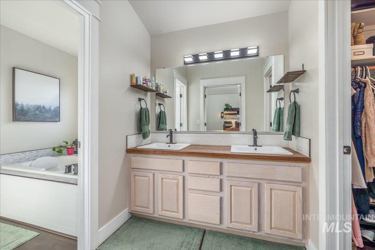 Full bathroom featuring double vanity and a tub