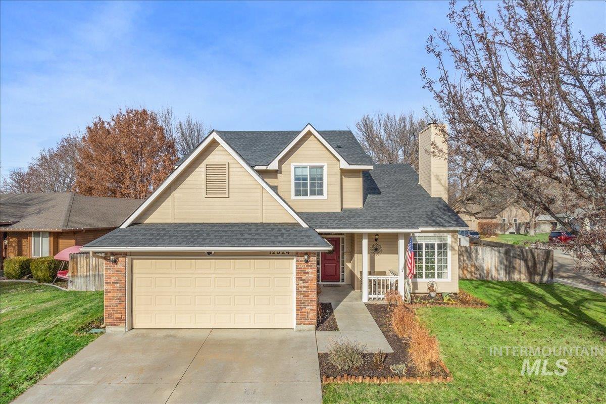 Traditional home with a porch, roof with shingles, driveway, a chimney, and brick siding