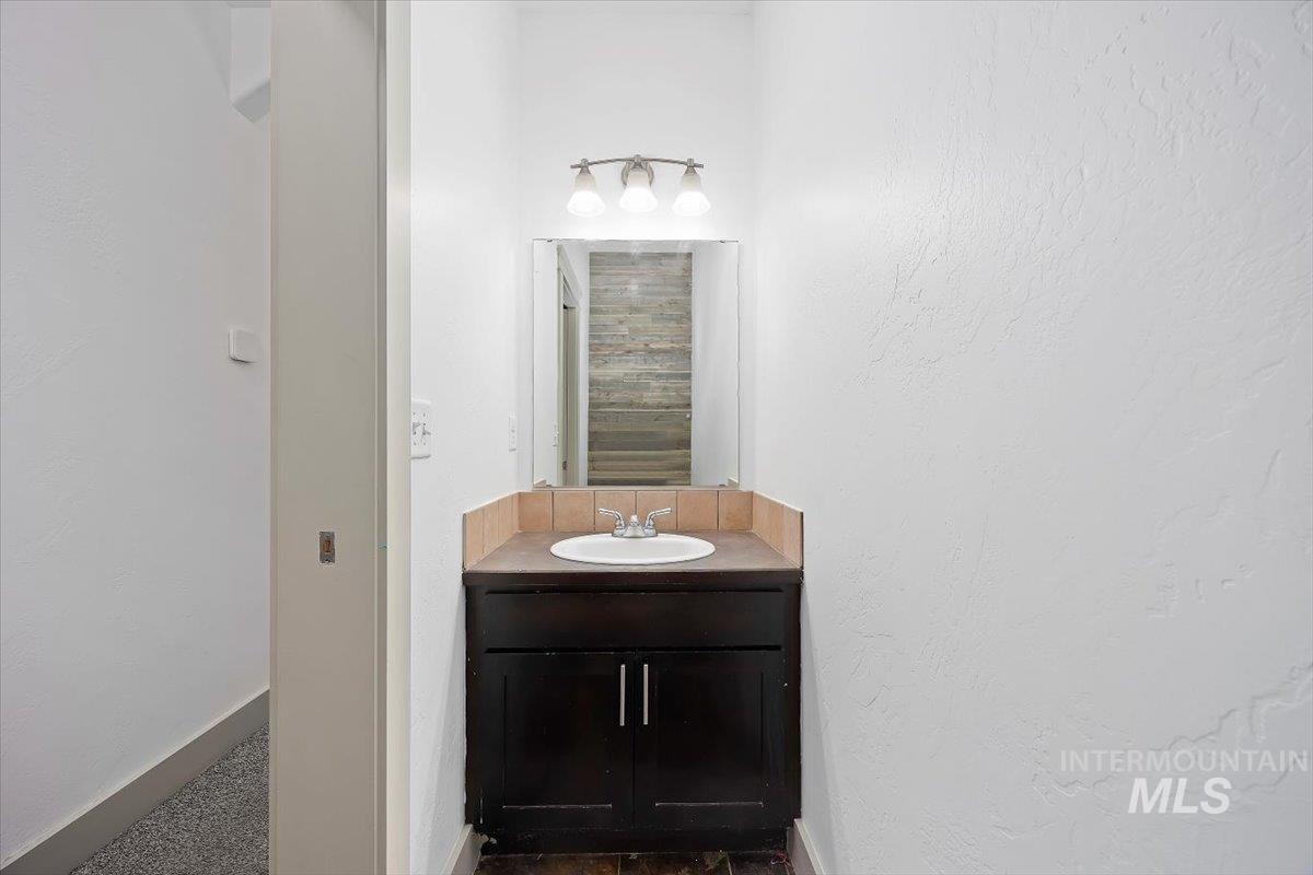 Bathroom featuring vanity and a textured wall