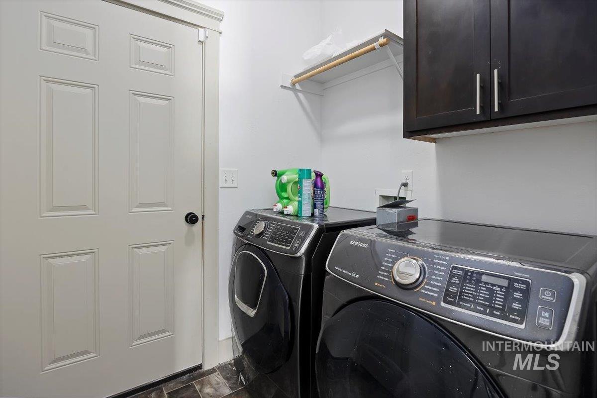 Laundry area featuring washer and clothes dryer and cabinet space