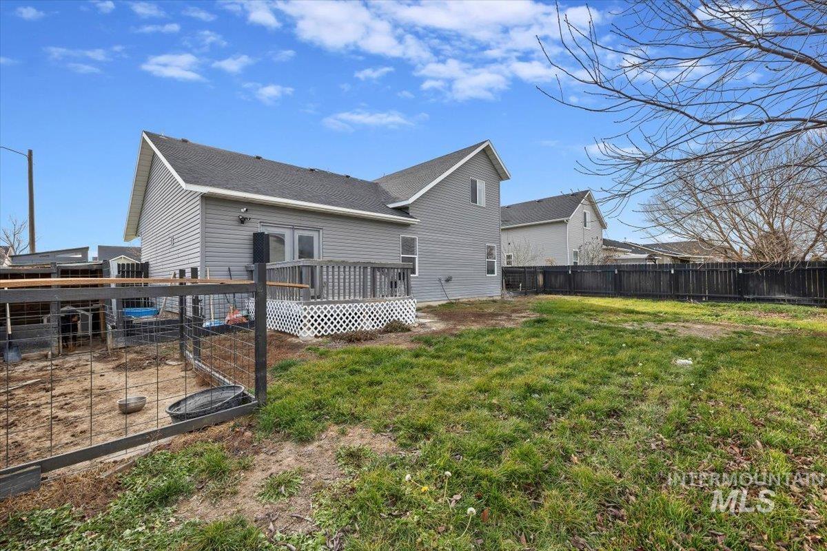 Rear view of house featuring a fenced backyard and a wooden deck