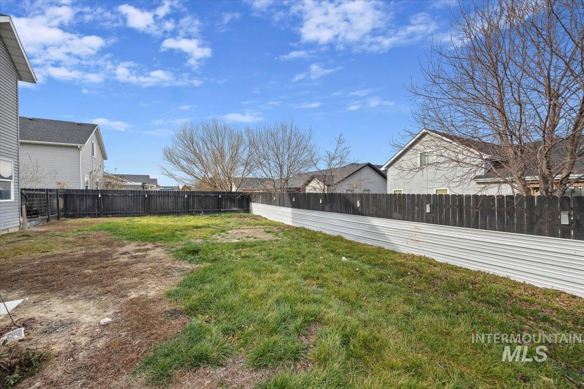 Fenced backyard featuring a residential view
