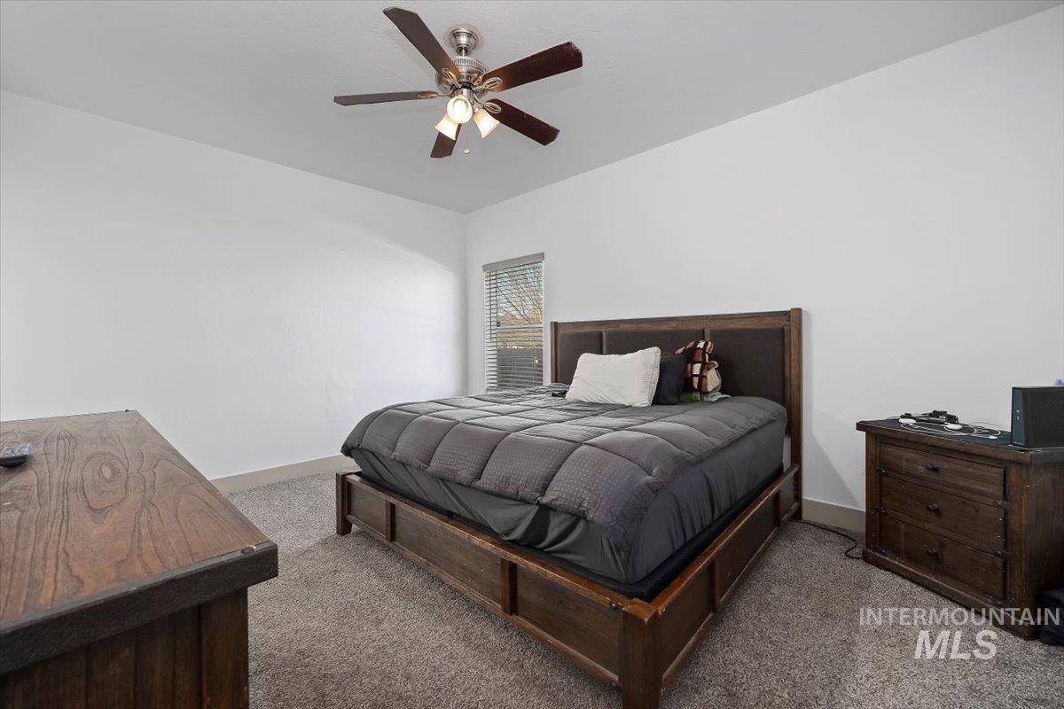 Bedroom with a ceiling fan and carpet floors
