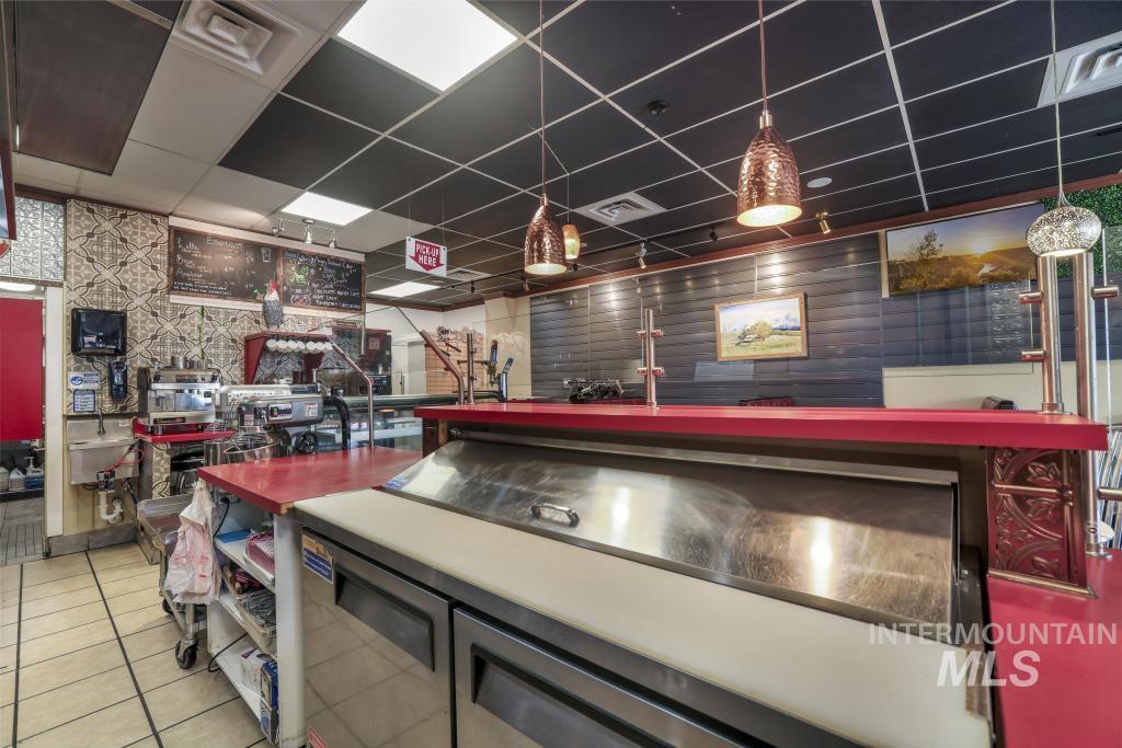 Game room featuring a paneled ceiling, light tile patterned floors, and wallpapered walls