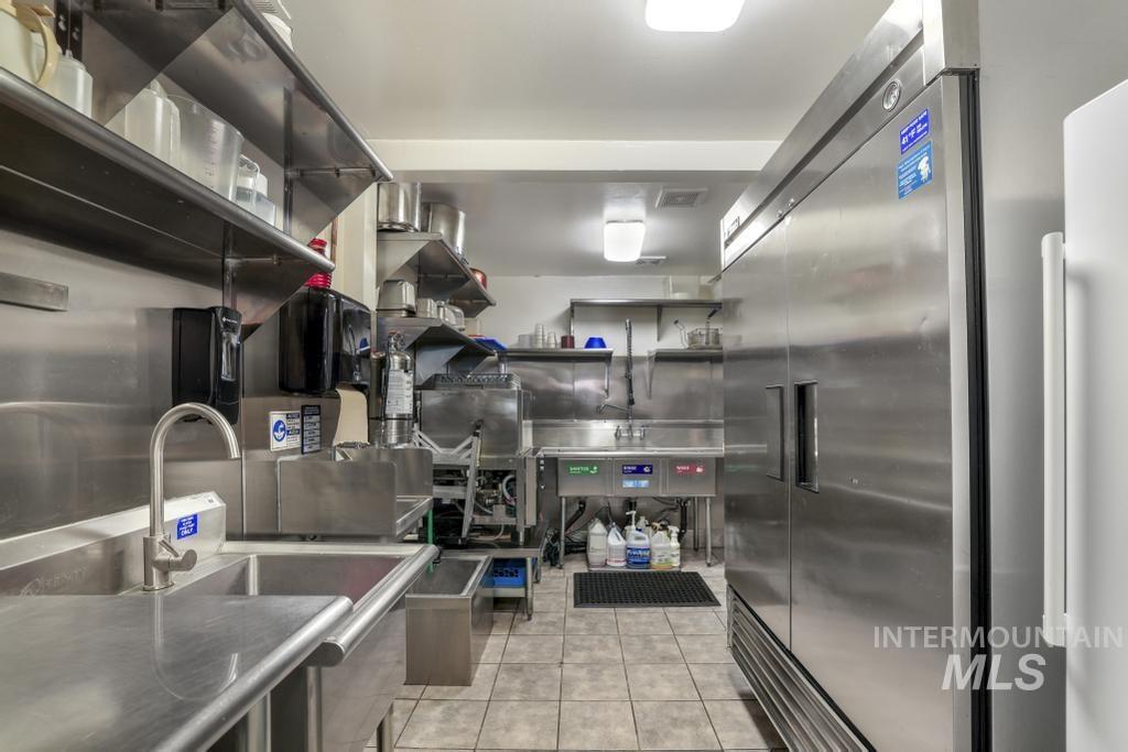 Kitchen with high end fridge and light tile patterned flooring