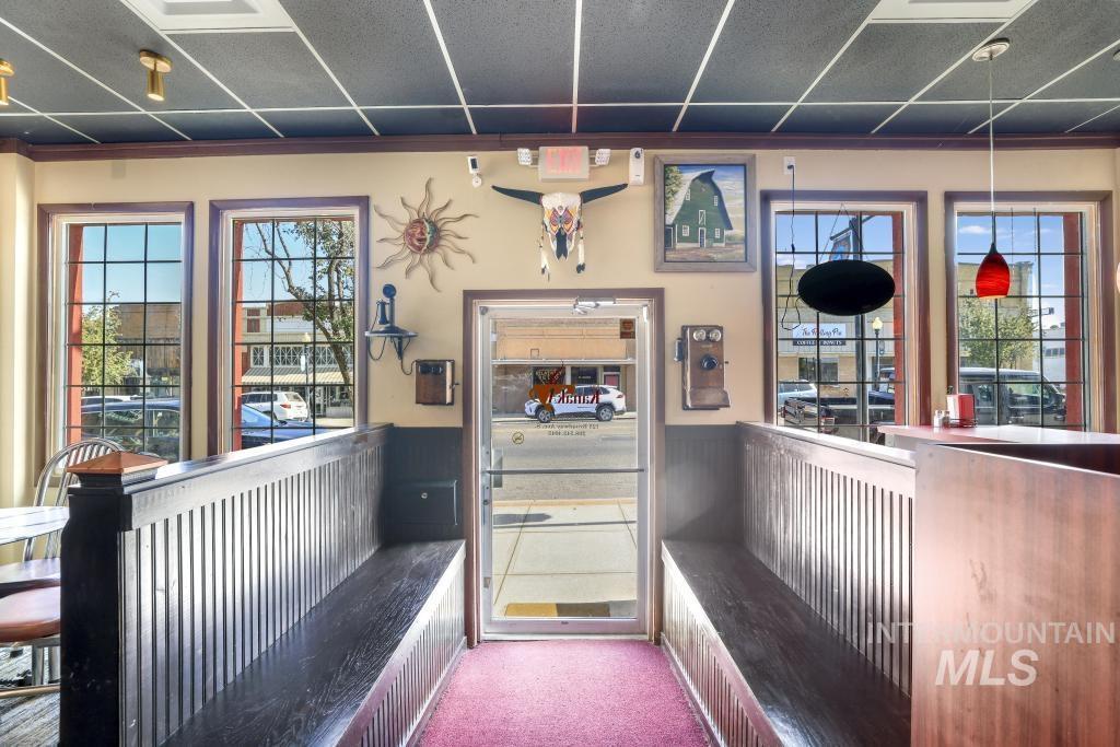 Interior space featuring carpet flooring, a wainscoted wall, and a drop ceiling
