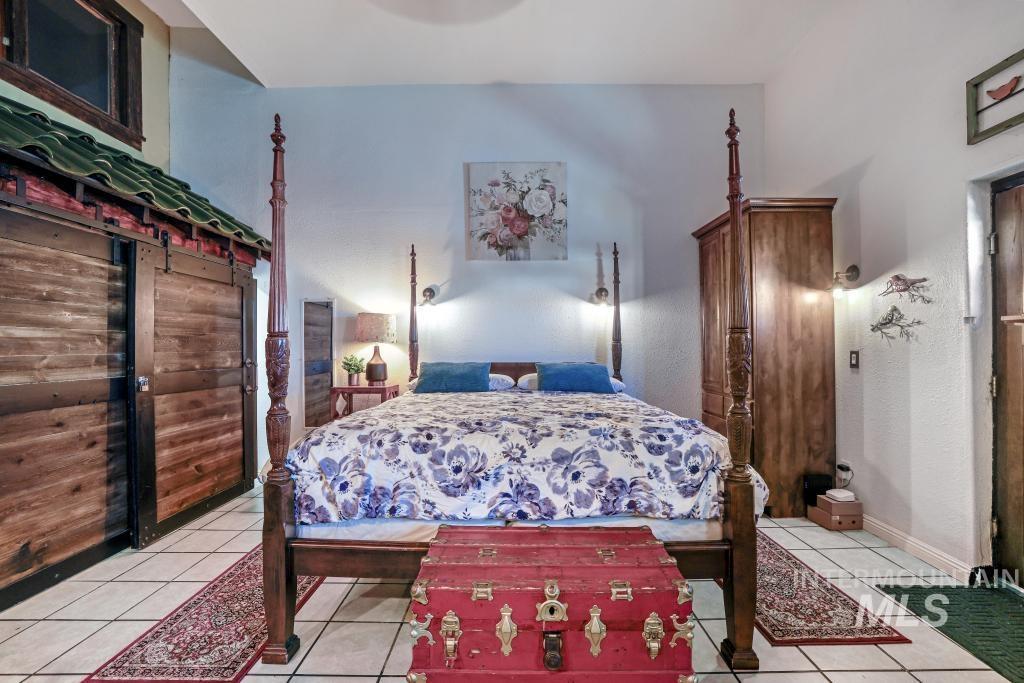Bedroom featuring light tile patterned flooring and baseboards