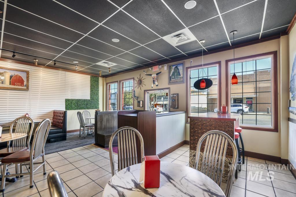 Dining room featuring tile patterned flooring, healthy amount of natural light, and a paneled ceiling