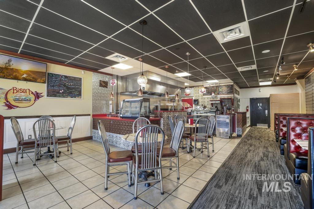 Dining space with a paneled ceiling and tile patterned flooring