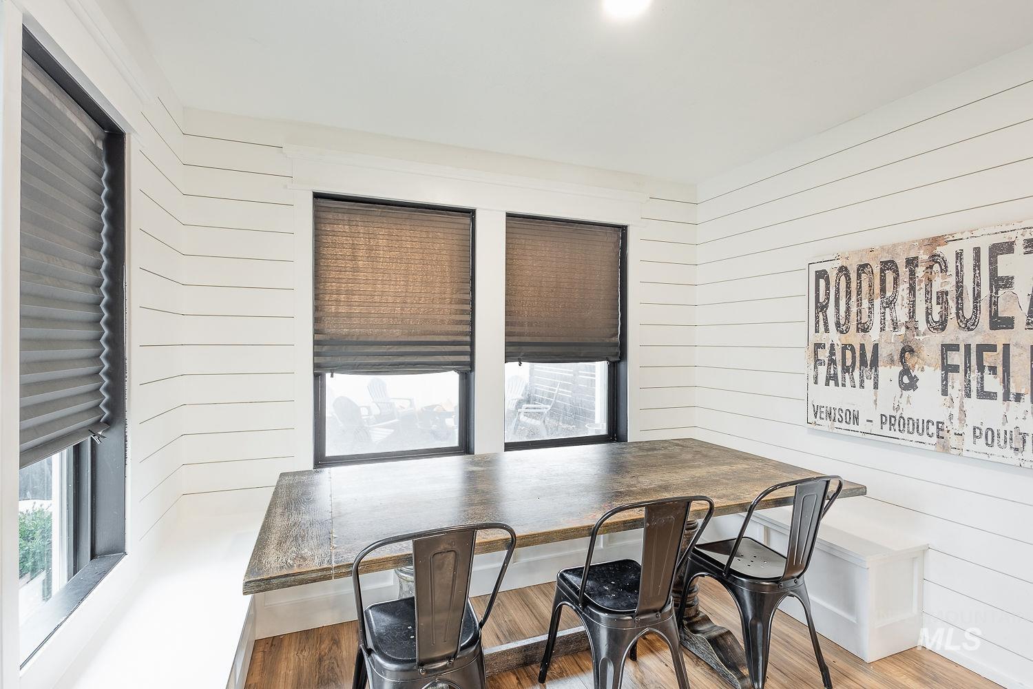 Dining room featuring wood walls and wood finished floors
