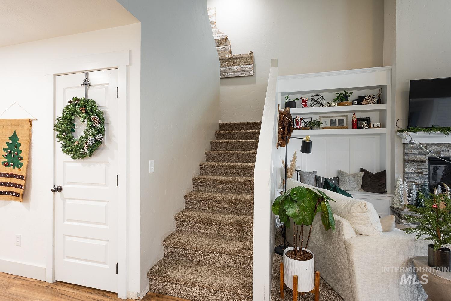 Stairway with a fireplace and wood finished floors