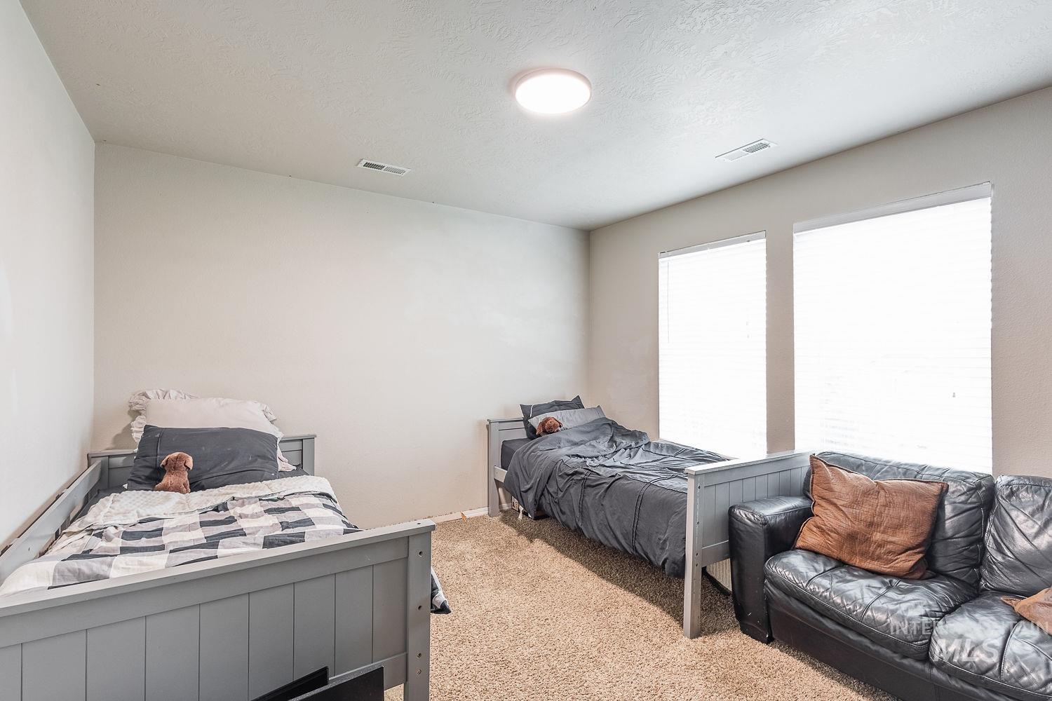Bedroom featuring a textured ceiling and carpet floors