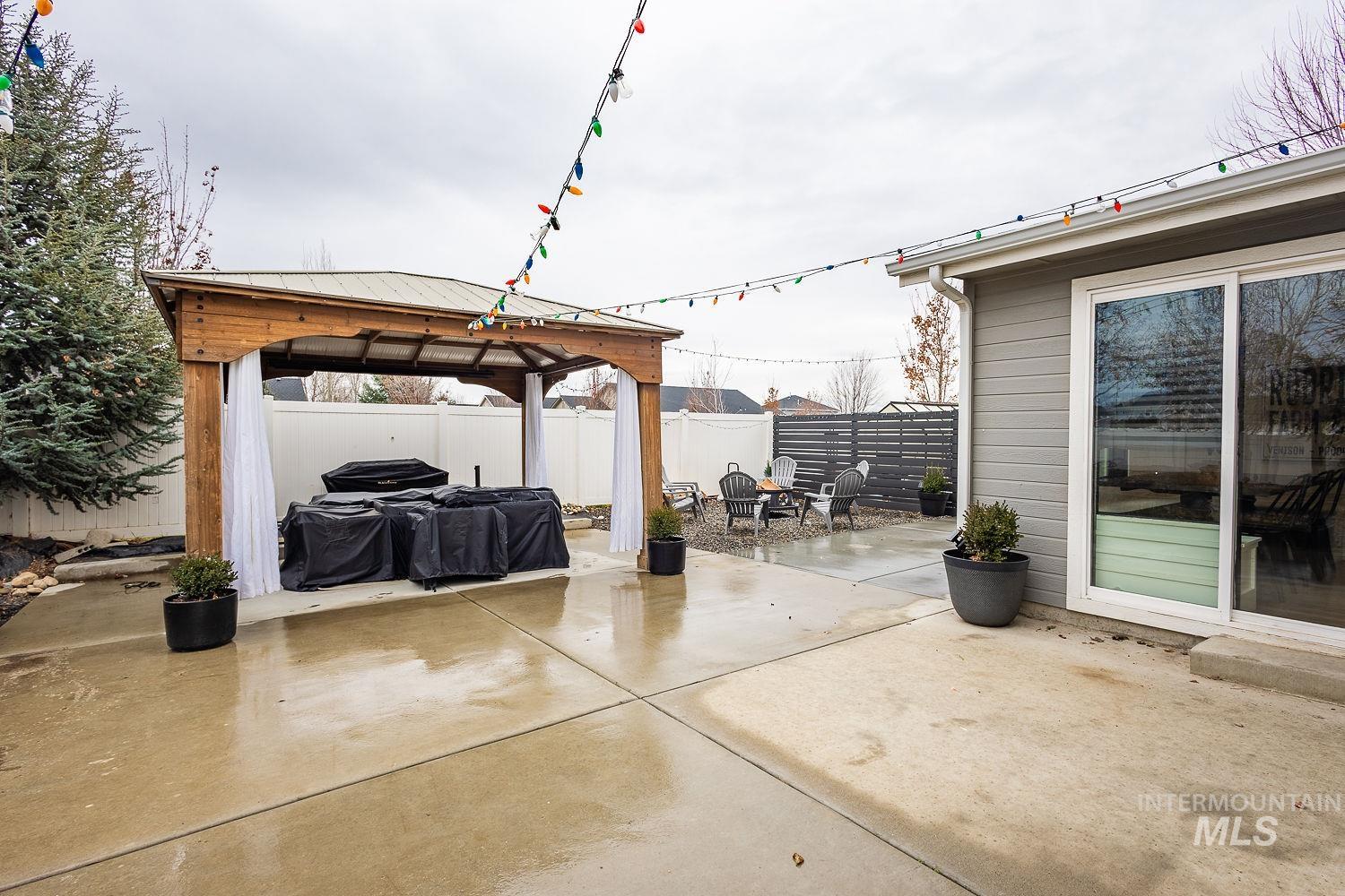 Fenced backyard with a patio, a gazebo, and area for grilling
