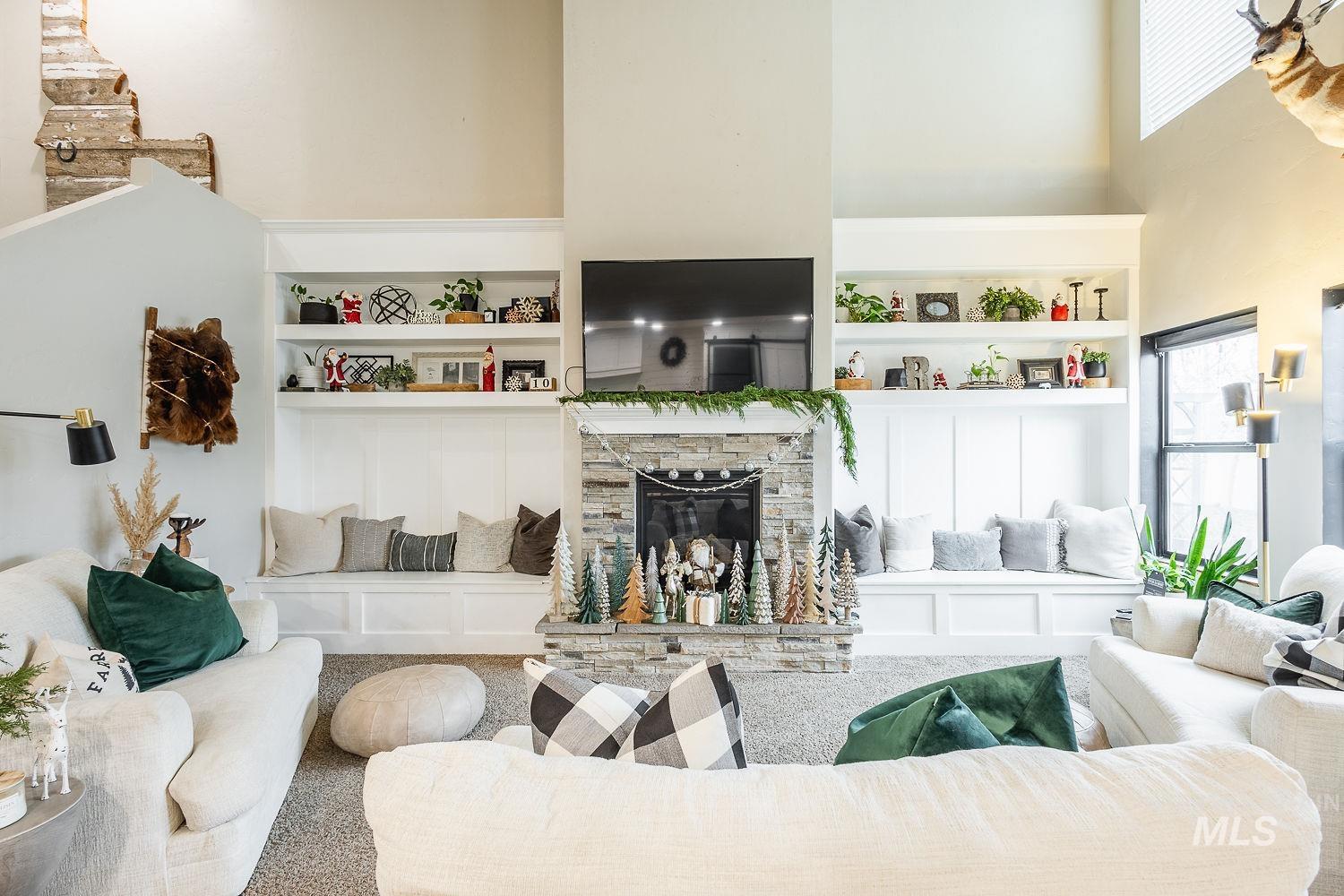 Living area with a towering ceiling, built in features, a fireplace, and carpet flooring