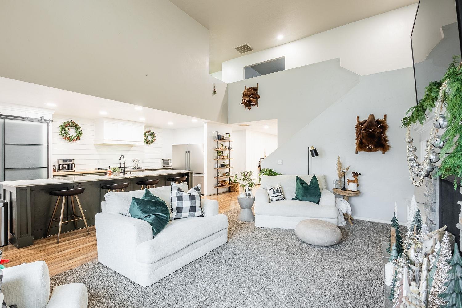 Living area featuring a towering ceiling, recessed lighting, and light wood-style flooring