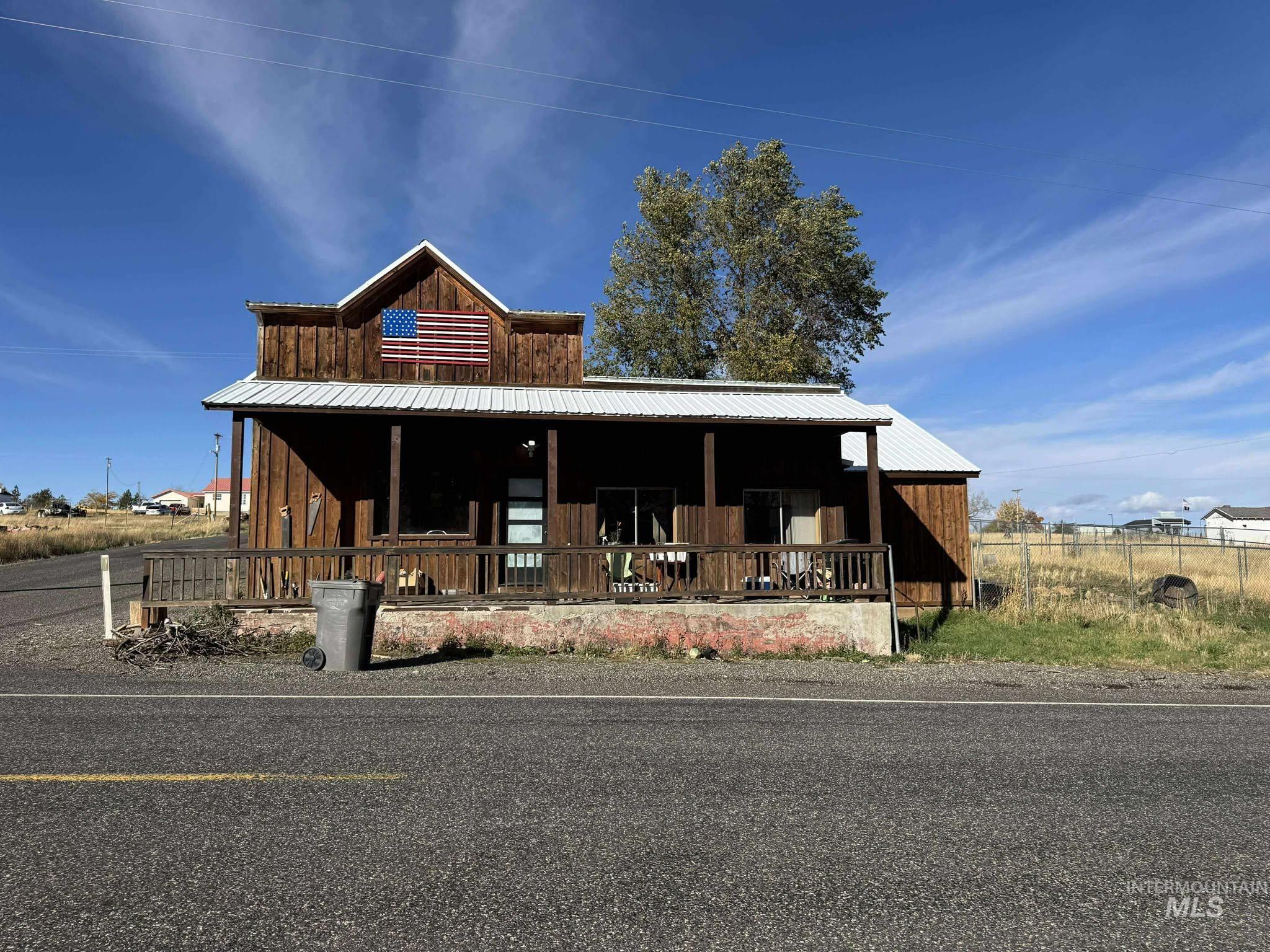 View of front facade featuring a porch, a metal roof, and board and batten siding