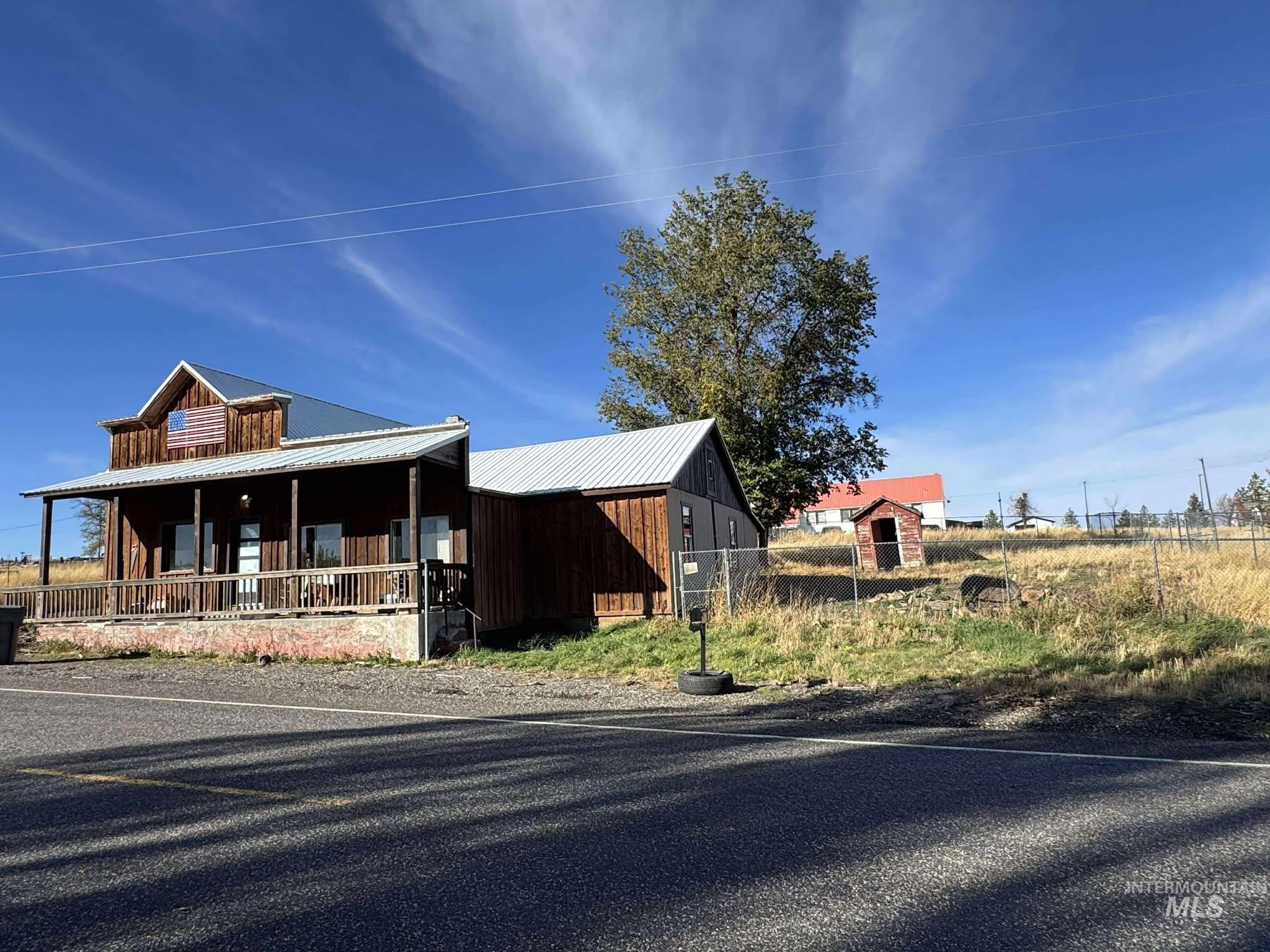 View of front of home featuring a porch, a metal roof, and board and batten siding
