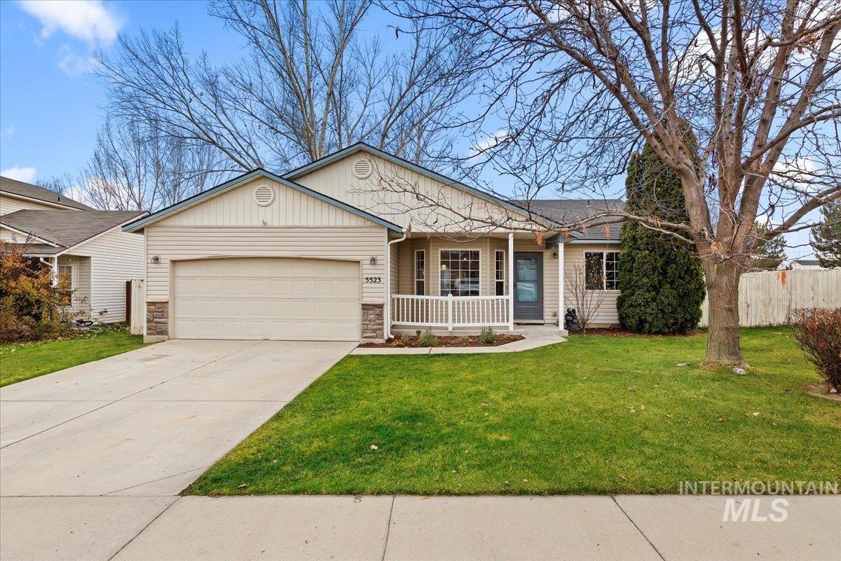 Ranch-style home with covered porch, driveway, an attached garage, and stone siding
