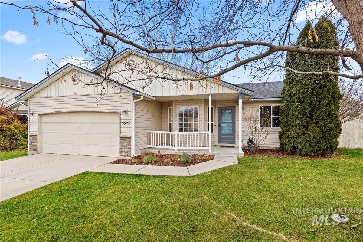 Ranch-style home with covered porch, stone siding, concrete driveway, and an attached garage