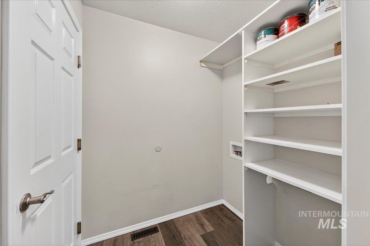 Walk in closet featuring dark wood-type flooring