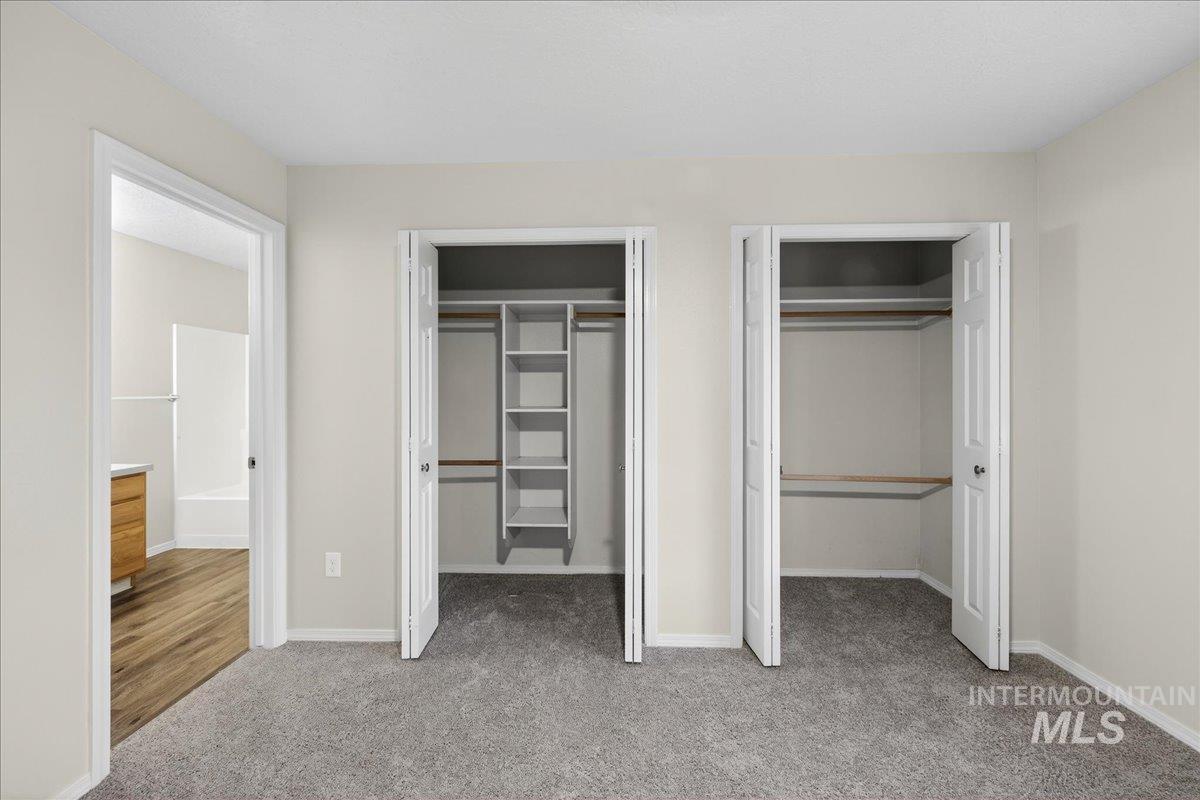 Unfurnished bedroom featuring multiple closets and light colored carpet