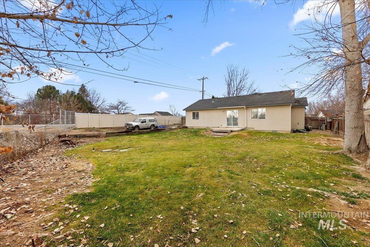 Back of house with a fenced backyard and a patio area