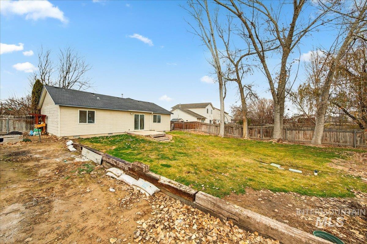 Back of property with a fenced backyard, a patio area, and crawl space