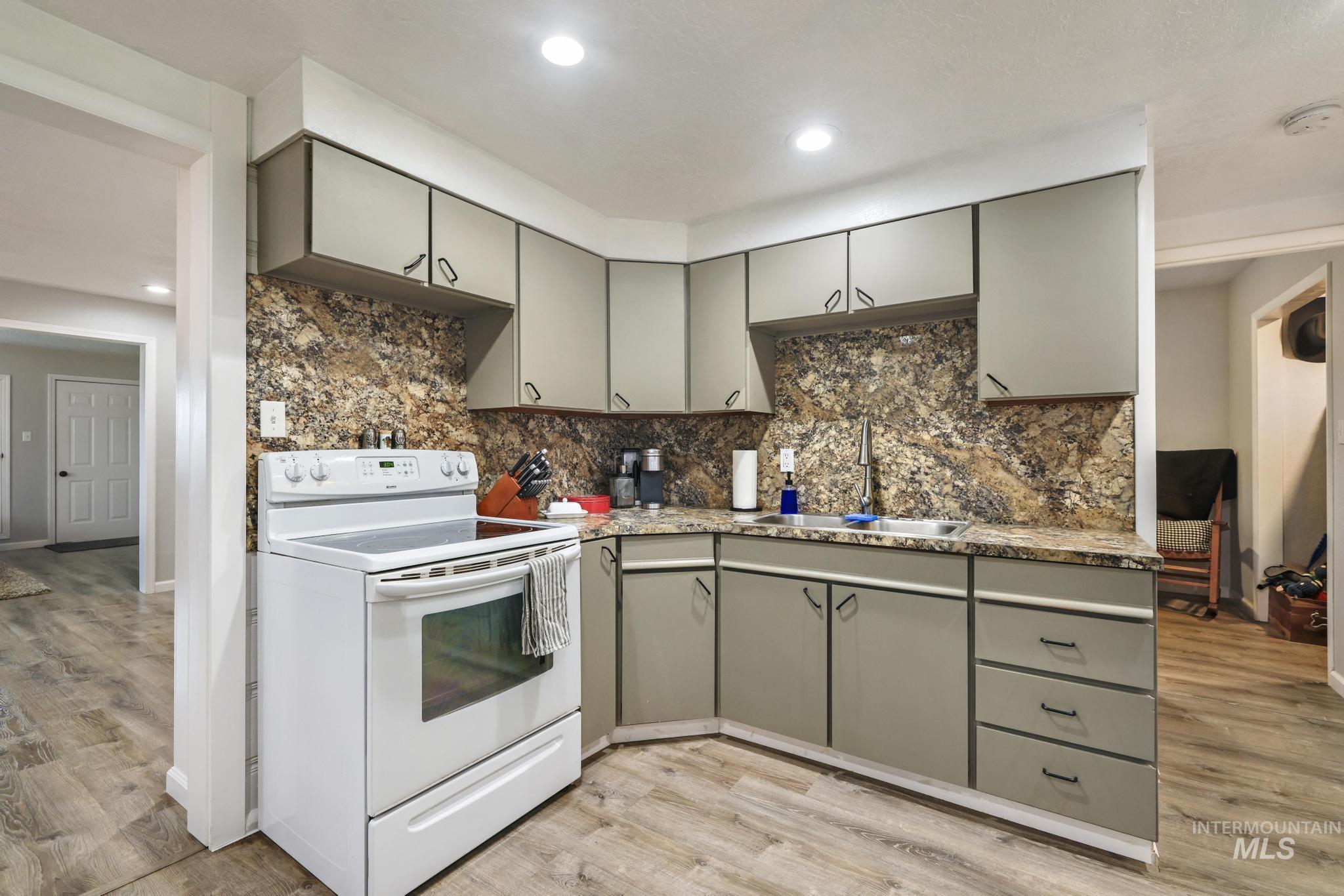 Kitchen featuring gray cabinetry, white electric range, light wood-type flooring, tasteful backsplash, and recessed lighting