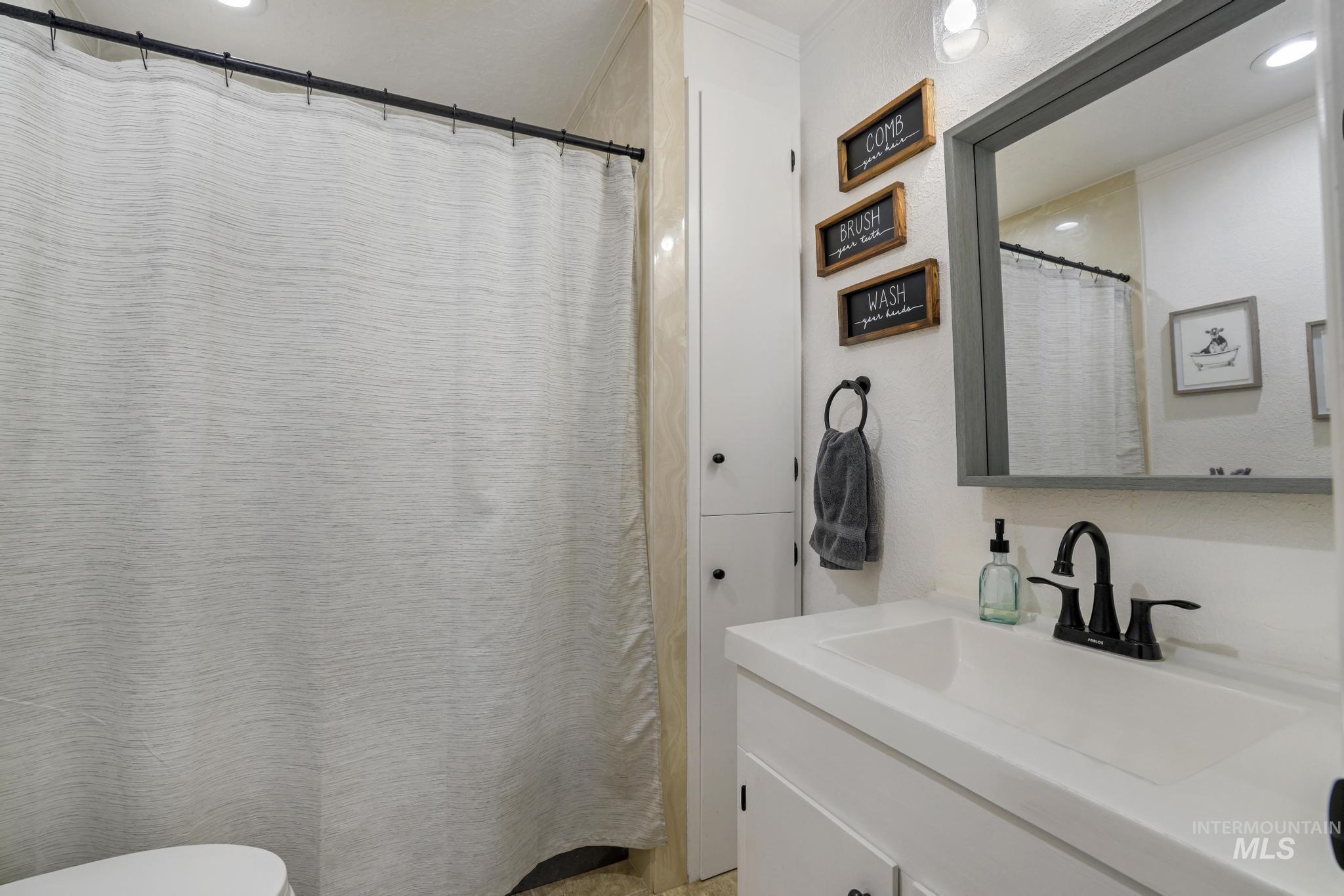 Full bathroom with vanity, recessed lighting, and a shower with curtain