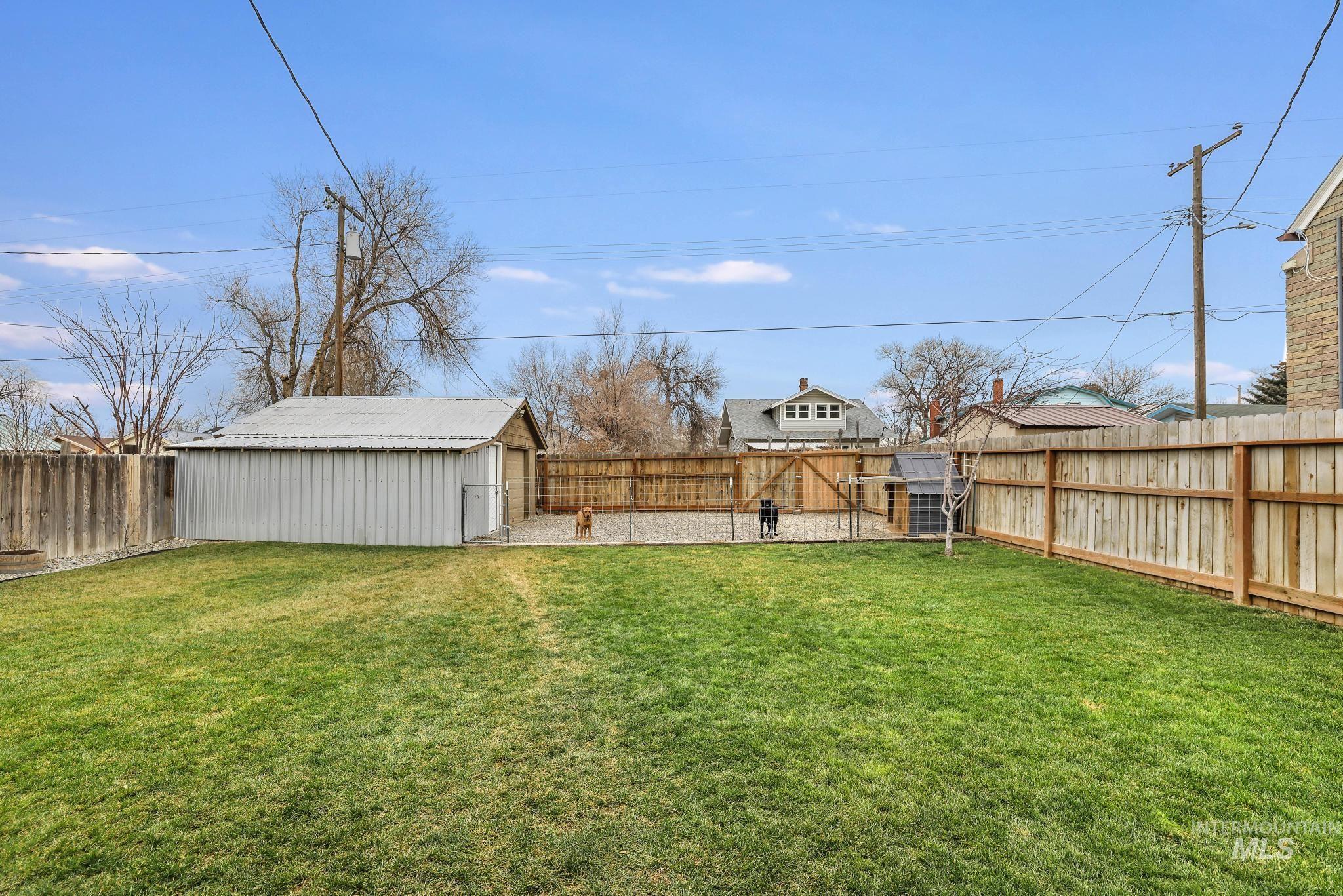 Fenced backyard featuring an outdoor structure