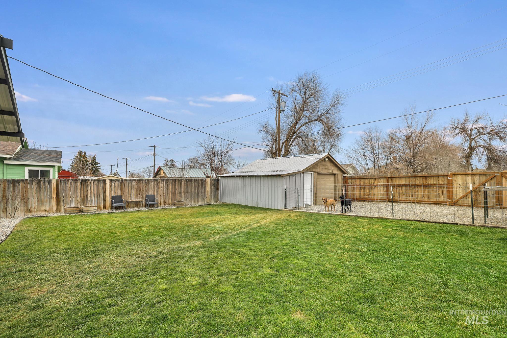 Fenced backyard with an outdoor structure