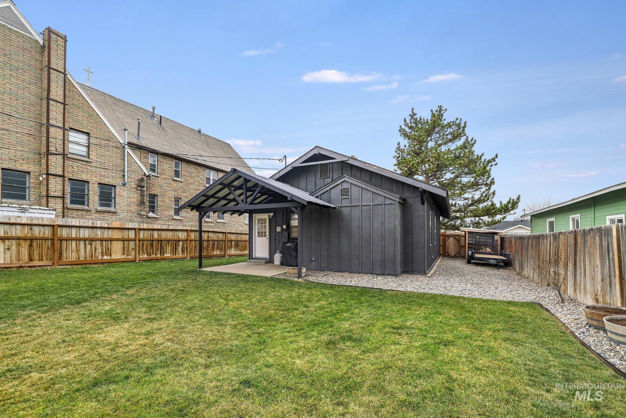 Back of house with a fenced backyard, an outbuilding, and board and batten siding