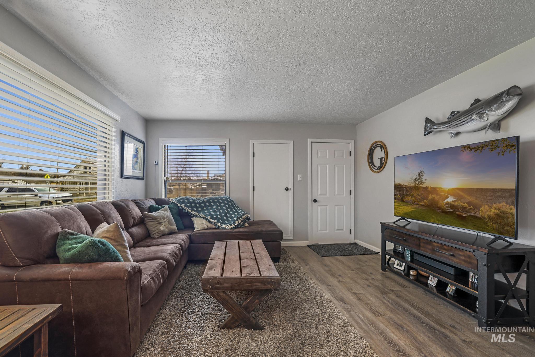 Living room with dark wood-style flooring and a textured ceiling