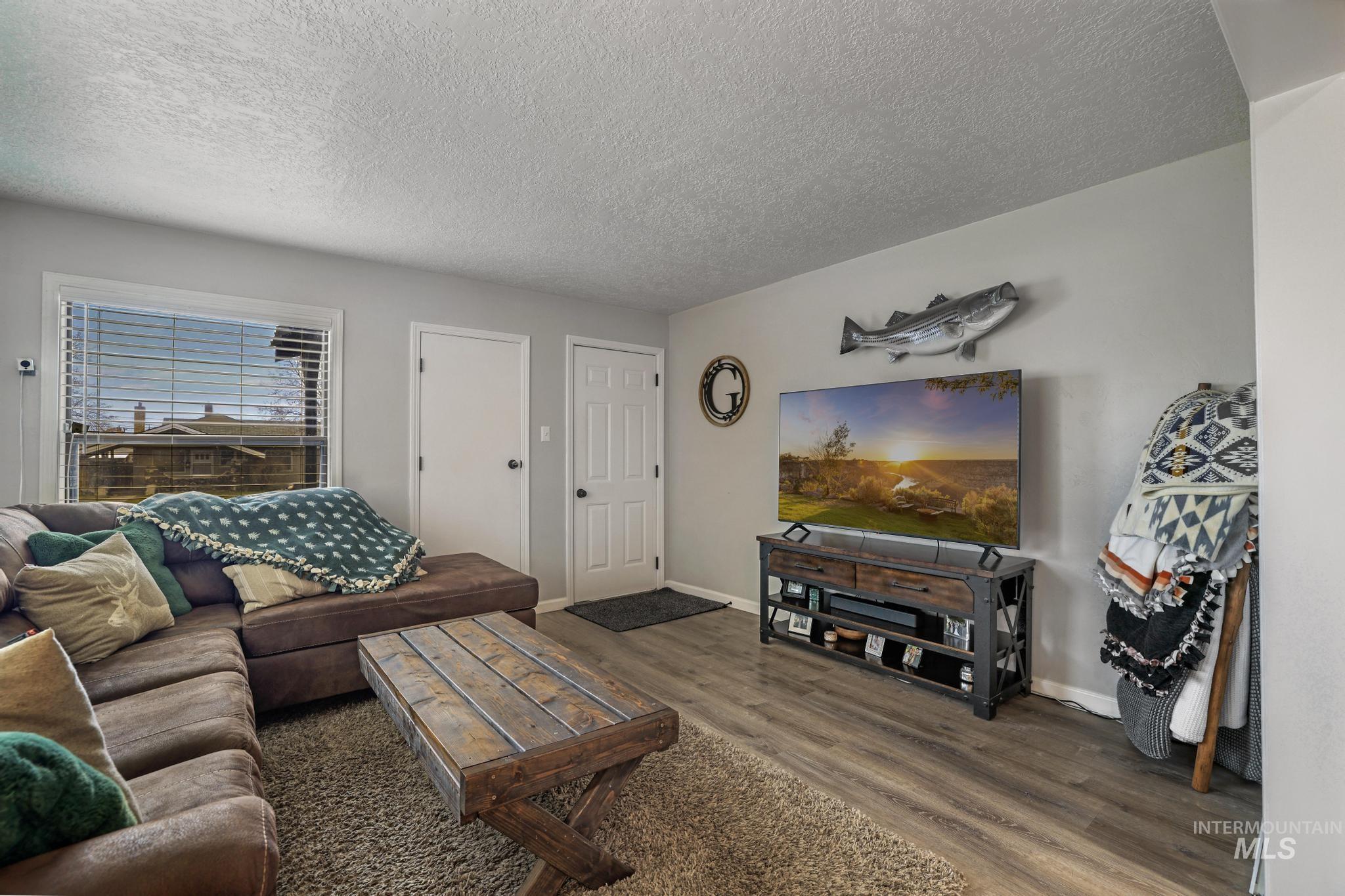 Living room featuring wood finished floors and a textured ceiling