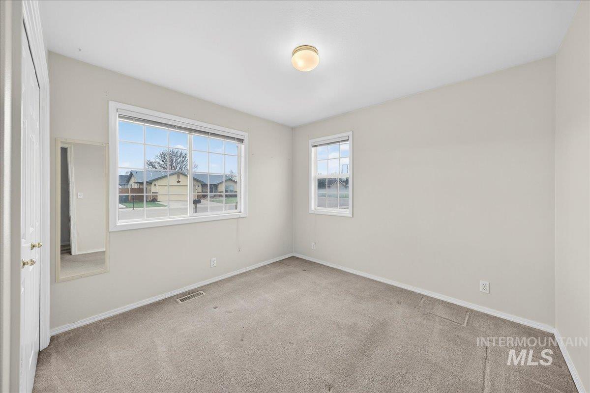 Carpeted empty room with baseboards