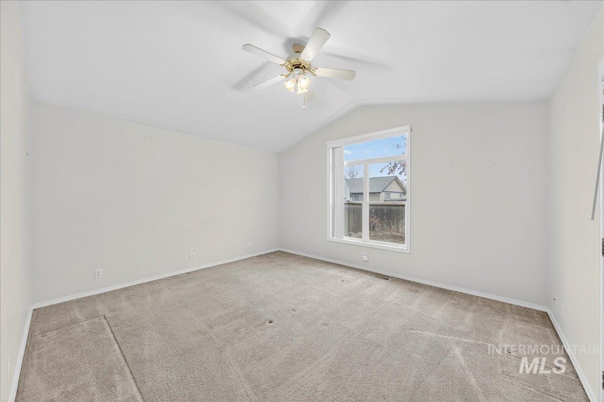 Bonus room with vaulted ceiling, light colored carpet, and ceiling fan