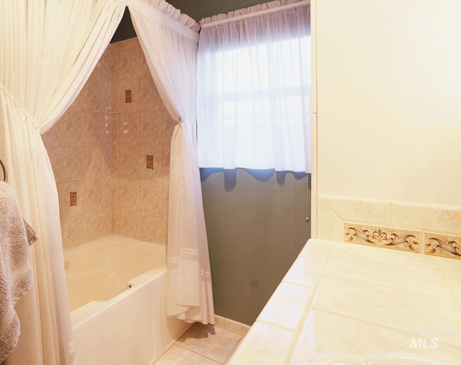 Full bathroom featuring vanity, shower / bathtub combination with curtain, and tile patterned floors