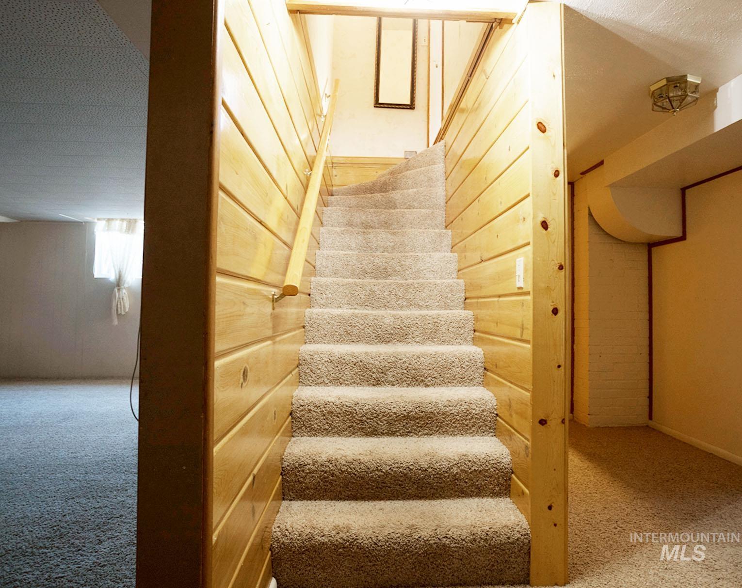 Stairway with carpet floors and a textured ceiling