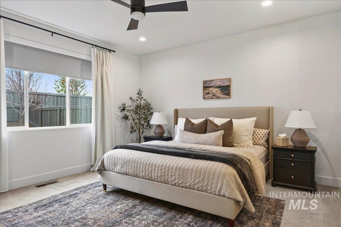 Carpeted bedroom with baseboards and a ceiling fan